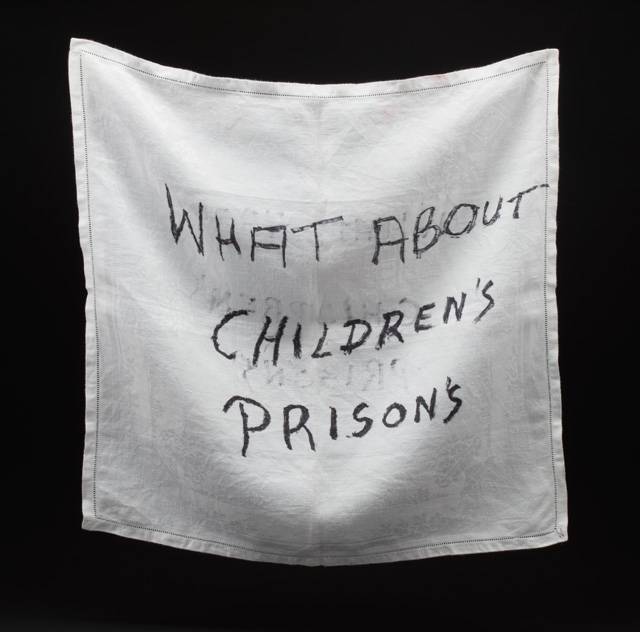 A white sheet inscripted with "WHat about Children's Prisons"