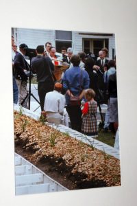 A crowd of people listening in front of a garden bed / mass grave