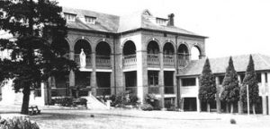 Photo showing a large two-storey building with arched, covered balconies